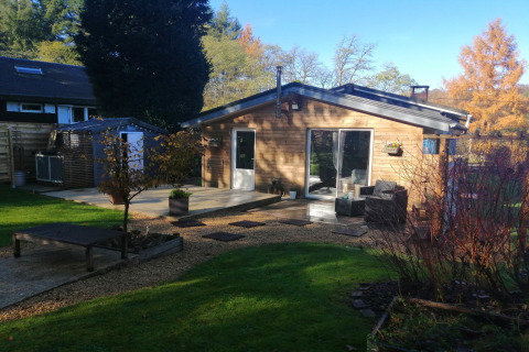 Houten lodge met terras, tuin en buitenzitje, gefotografeerd bij Chatillon 67.