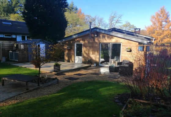 Houten lodge met terras, tuin en buitenzitje, gefotografeerd bij Chatillon 67.