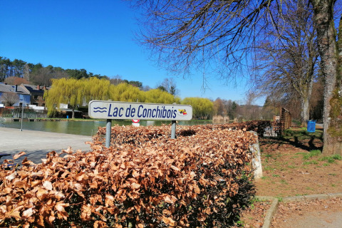 Uitzicht op Lac de Conchibois bij lodge Chatillon 67 in België, met blauwe lucht en bomen rondom.
