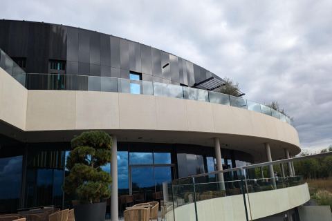 Moderne gevel van lodge Chatillon 67 in België, met glazen balustrades en gebogen terrassen.