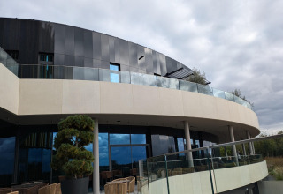 Moderne gevel van lodge Chatillon 67 in België, met glazen balustrades en gebogen terrassen.