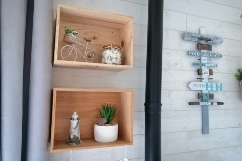 Wanddecoratie in Chatillon 67-lodge in België met houten kisten en een decoratief wegwijzerbord.