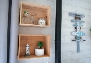 Wanddecoratie in Chatillon 67-lodge in België met houten kisten en een decoratief wegwijzerbord.