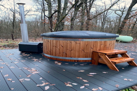 Udendørs træ-brændt vildmarksbad på terrasse i skovomgivelser ved Chalet «DES BOIS» i Belgien.
