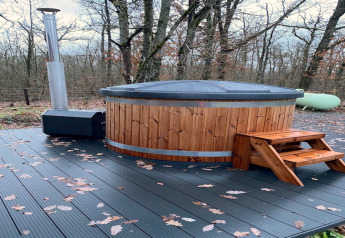 Vasca idromassaggio a legna all’aperto su terrazza nel bosco al Chalet «DES BOIS» in Belgio.