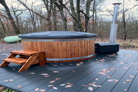 Udendørs spabad med trappe og trædæk, omgivet af træer, ved Chalet DES BOIS i Belgien om efteråret.