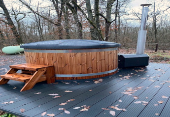 Vasca idromassaggio all’aperto con gradini in legno e terrazza presso Chalet DES BOIS in Belgio.