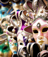 Máscaras coloridas y ornamentadas expuestas juntas, típicas del carnaval tradicional veneciano.