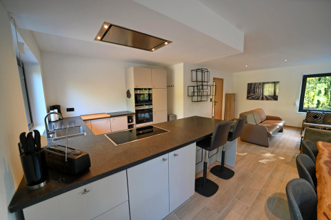 Moderne køkken og stue i Chalet «DES BOIS» i Belgien med åbent design og elegante møbler.