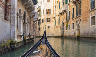 Vista desde una góndola en un canal estrecho rodeado de edificios antiguos en Cavallino, Véneto, Italia.