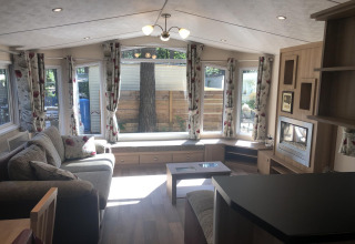 Lyst og rummeligt opholdsrum i chalet 'Koperwiek' i Belgien med store vinduer og moderne indretning.