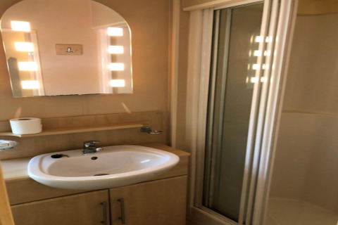 Bagno presso la lodge Bosuil in Belgio con lavandino, specchio illuminato e box doccia.