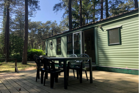 Udendørs terrasse ved lodge ‘Sijs’ i Belgien med grønne omgivelser og afslapningsmuligheder.