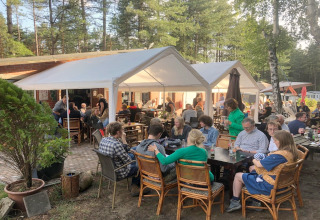 Repas en plein air à la lodge Sparrowhawk en Belgique, des convives savourent leur dîner sous les arbres.