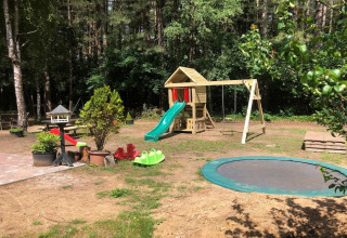 Aire de jeux extérieure au lodge Sparrowhawk en Belgique avec toboggan, balançoires et trampoline.