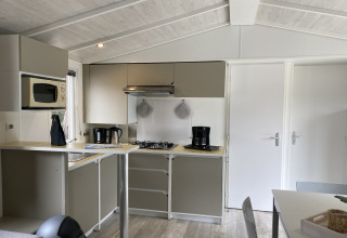 Angolo cottura moderno a Verblijfpark Breebos 2 in Belgio con fornello, macchina da caffè e mobili chiari.