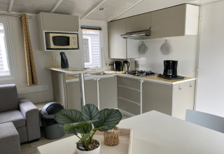Cucina moderna di una lodge con fornello, macchina da caffè e microonde al Verblijfpark Breebos 2 in Belgio.