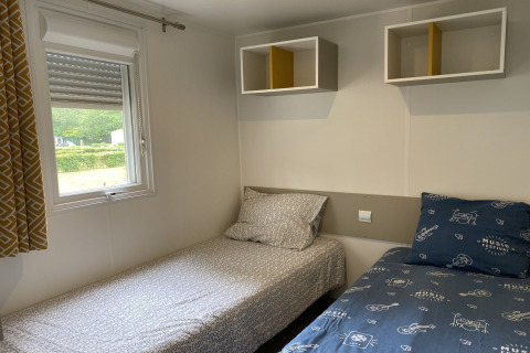 Stanza con due letti singoli e scaffali a parete presso il lodge Verblijfpark Breebos 2 in Belgio.