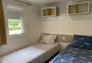Stanza con due letti singoli e scaffali a parete presso il lodge Verblijfpark Breebos 2 in Belgio.