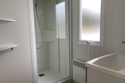 Bagno moderno con box doccia, lavandino e finestra al lodge Verblijfpark Breebos 2 in Belgio.