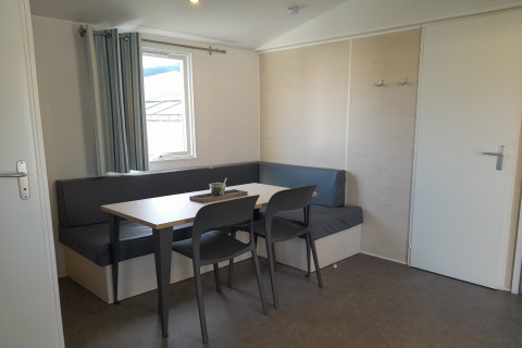 Moderne eethoek met hoekbank, tafel en vier stoelen in Verblijfpark Breebos 3, België.