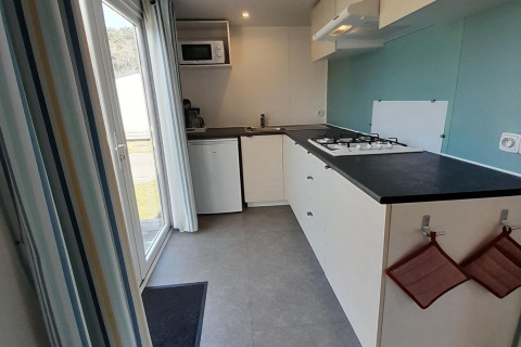 Moderne, compacte keuken in een lodge op Verblijfpark Breebos 3, België, met fornuis en mini-koelkast.