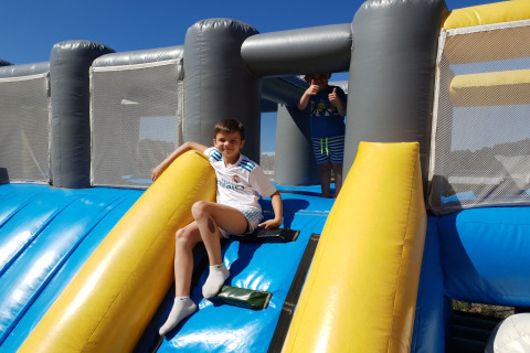 Twee jongens spelen op een grote blauw-gele springkussen-glijbaan bij Verblijfpark Breebos 3 in België.