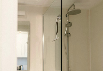 Ducha moderna con mampara de cristal y maquinilla de afeitar en Chalet «Chocolat» en Bélgica.