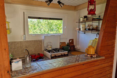 Acogedora cocina pequeña en el chalet Casita La Luna en Bélgica, con ventana y estufa de gas.