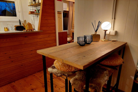 Acogedor interior de chalet Casita La Luna en Bélgica con mesa de madera, lámpara y decoración rústica.