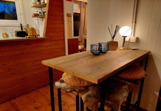 Acogedor interior de chalet Casita La Luna en Bélgica con mesa de madera, lámpara y decoración rústica.
