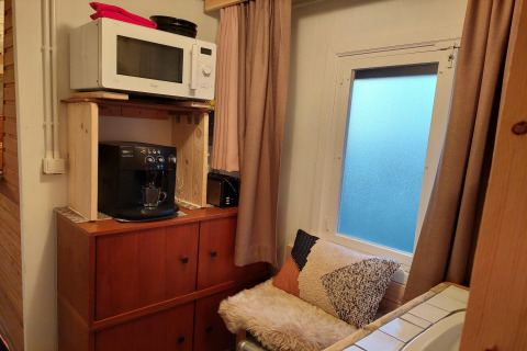 Rincón acogedor en el chalet Casita La Luna en Bélgica con microondas, cafetera y zona de asientos.