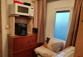 Rincón acogedor en el chalet Casita La Luna en Bélgica con microondas, cafetera y zona de asientos.