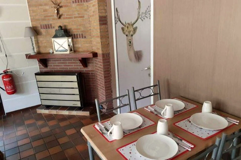 Eetzaal in lodge The Deer Forest in België, gedekte tafel voor vier en deur met hertenhoofd.
