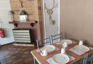 Sala da pranzo della lodge The Deer Forest in Belgio, tavola apparecchiata e porta decorata con cervo.