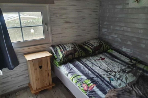 Chambre confortable à la cabane The Deer Forest en Belgique, décor forestier et linge de lit à motif cerf.