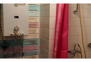 Badkamer in The Deer Forest lodge in België met een douche, waterverwarmer en roze douchegordijn.