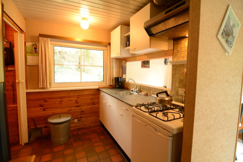 Acogedora cocina de Forest House the Squirrel en Bélgica, con revestimiento de madera y cocina de gas.
