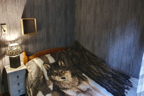 Chambre chaleureuse à Forest House the Squirrel, Belgique, avec linge de lit loup et déco boisée.