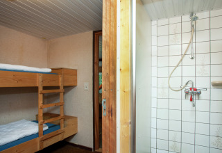 Chambre au Forest House the Squirrel en Belgique, avec lits superposés et douche séparée par une porte.