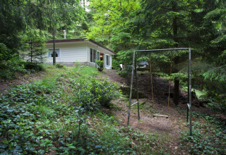 Petite maison en forêt verdoyante avec balançoire devant, Forest House the Squirrel, en Belgique.