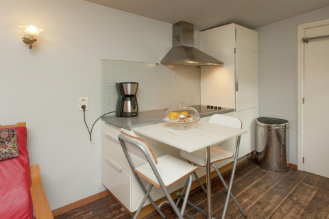 Moderne kitchenette met tafel, stoelen en koffiezet bij The Wijerschans in België.