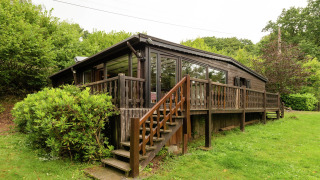 Foto del lodge Le Chession con terrazza in legno, scala e tanto verde in un ambiente tranquillo.