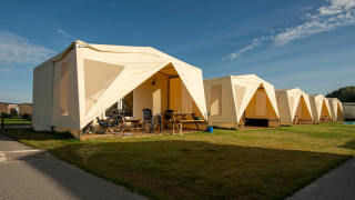 Safaritenten op Resort Beachside 5 met picknicktafels en fietsen buiten, zonnige dag, buitenaanzicht.