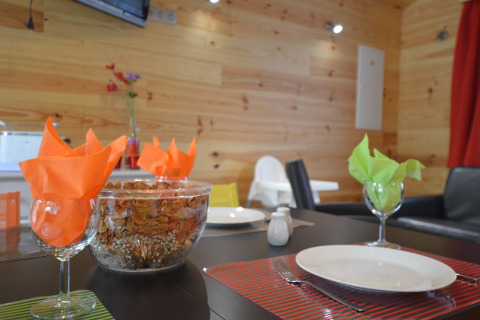 Dining table with colorful napkins and decor at Le Chalet Chaleureux A, Belgium, wooden wall interior.