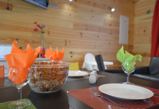 Dining table with colorful napkins and decor at Le Chalet Chaleureux A, Belgium, wooden wall interior.