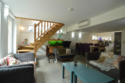 Moderne woonkamer in lodge 'Le coeur du brâme' in België met aquarium, trap en eetgedeelte.