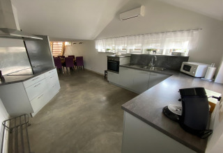 Moderne keuken in Le coeur du brâme lodge in België met grijze kasten, koffiezetapparaat en eetruimte.
