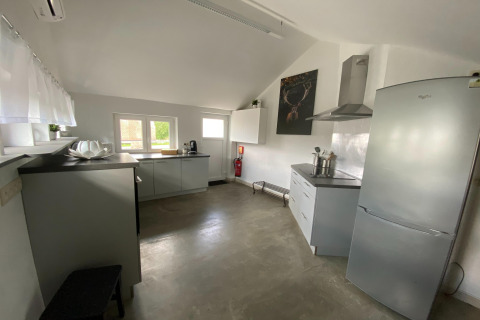 Moderne, ruime keuken met grijze kasten en grote koelkast in ‘Le coeur du brâme’, België.