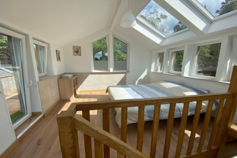 Lichte slaapkamer met dakramen en veel ramen in de lodge «Le coeur du brâme» in België.